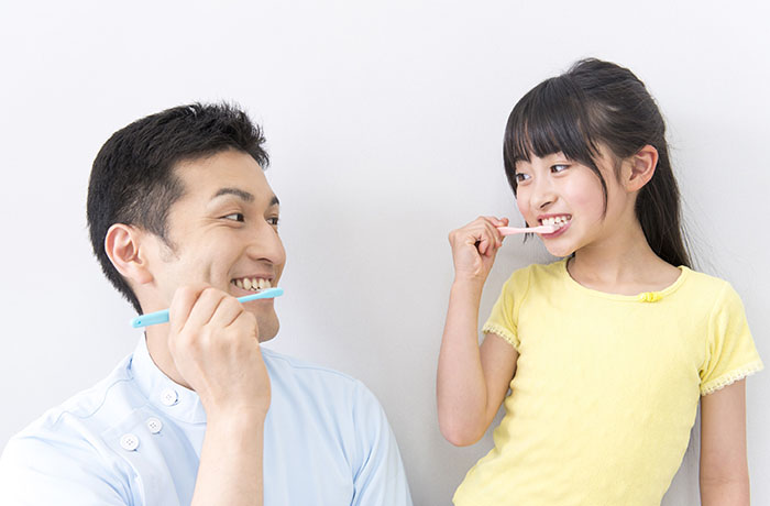 歯磨きをする男性と女の子